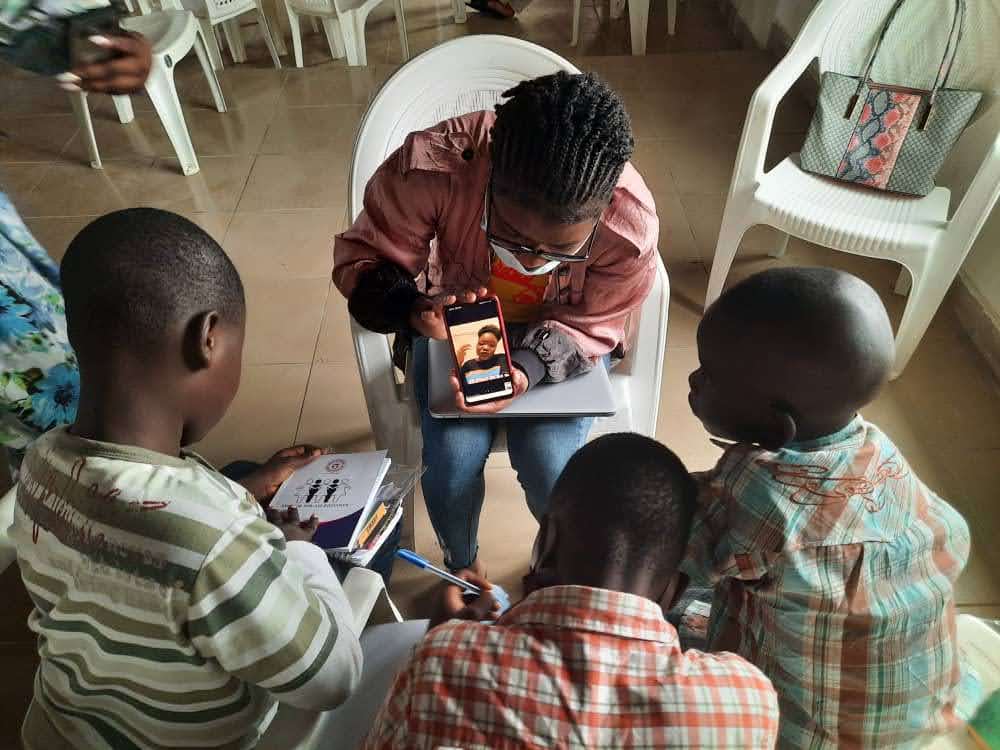 QWFN Volunteer holding a smart phone for mentees to watch and listen to mentor